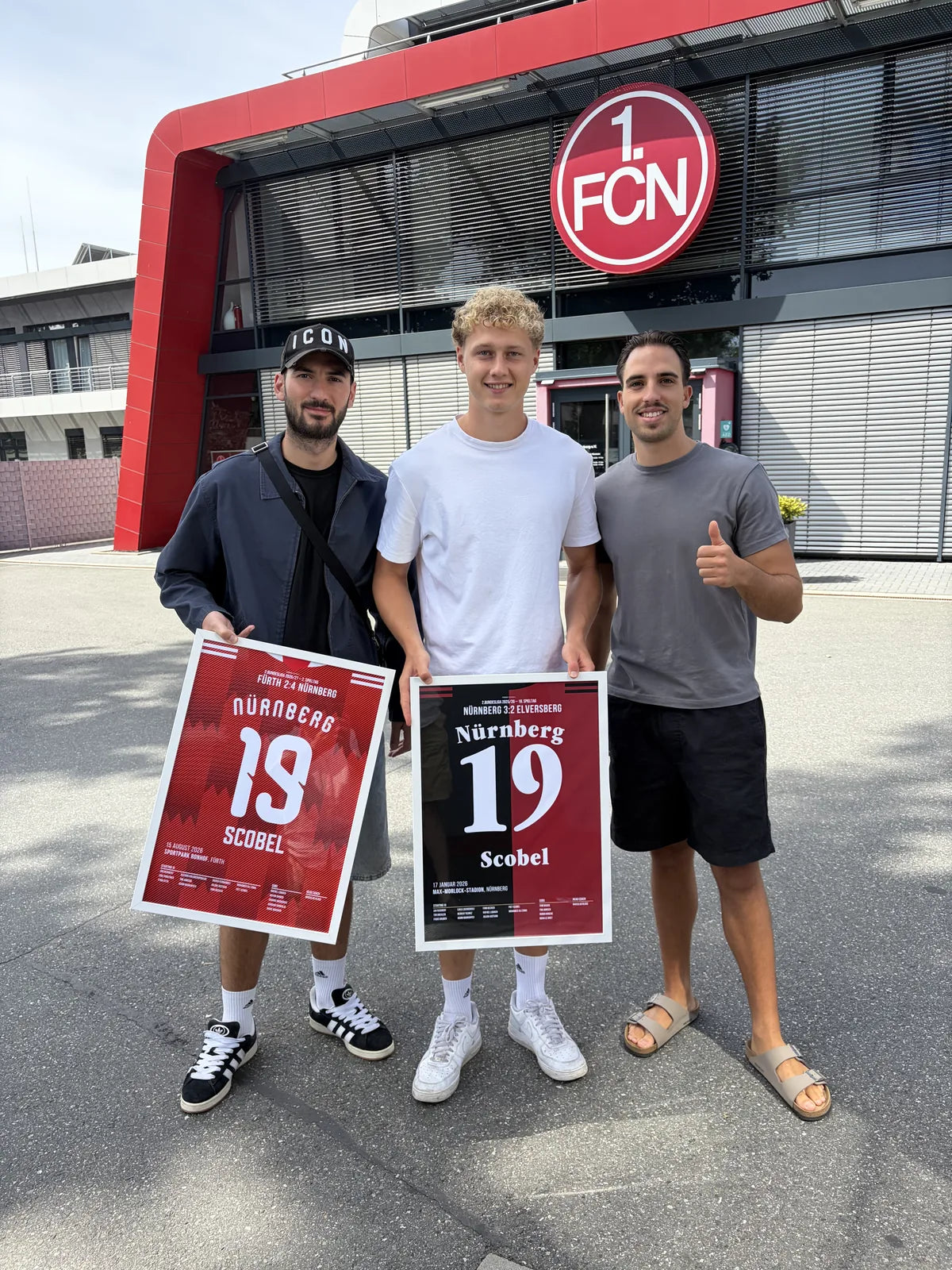 Gerahmte Nürnberg-Poster in Kundenhand vor dem Stadion des 1. FCN