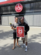 Gerahmtes Nürnberg-Poster in Kundenhand vor dem Stadion des 1. FCN